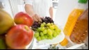 Man takes grapes from the refrigerator