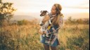 woman holding jack russell in a field