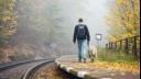 man walking along platform with yellow labrador