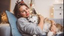 woman wearing antlers hugging her sleeping dog