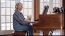 Dog listening to owner play the piano