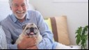 Man smiling and hugging his dog 